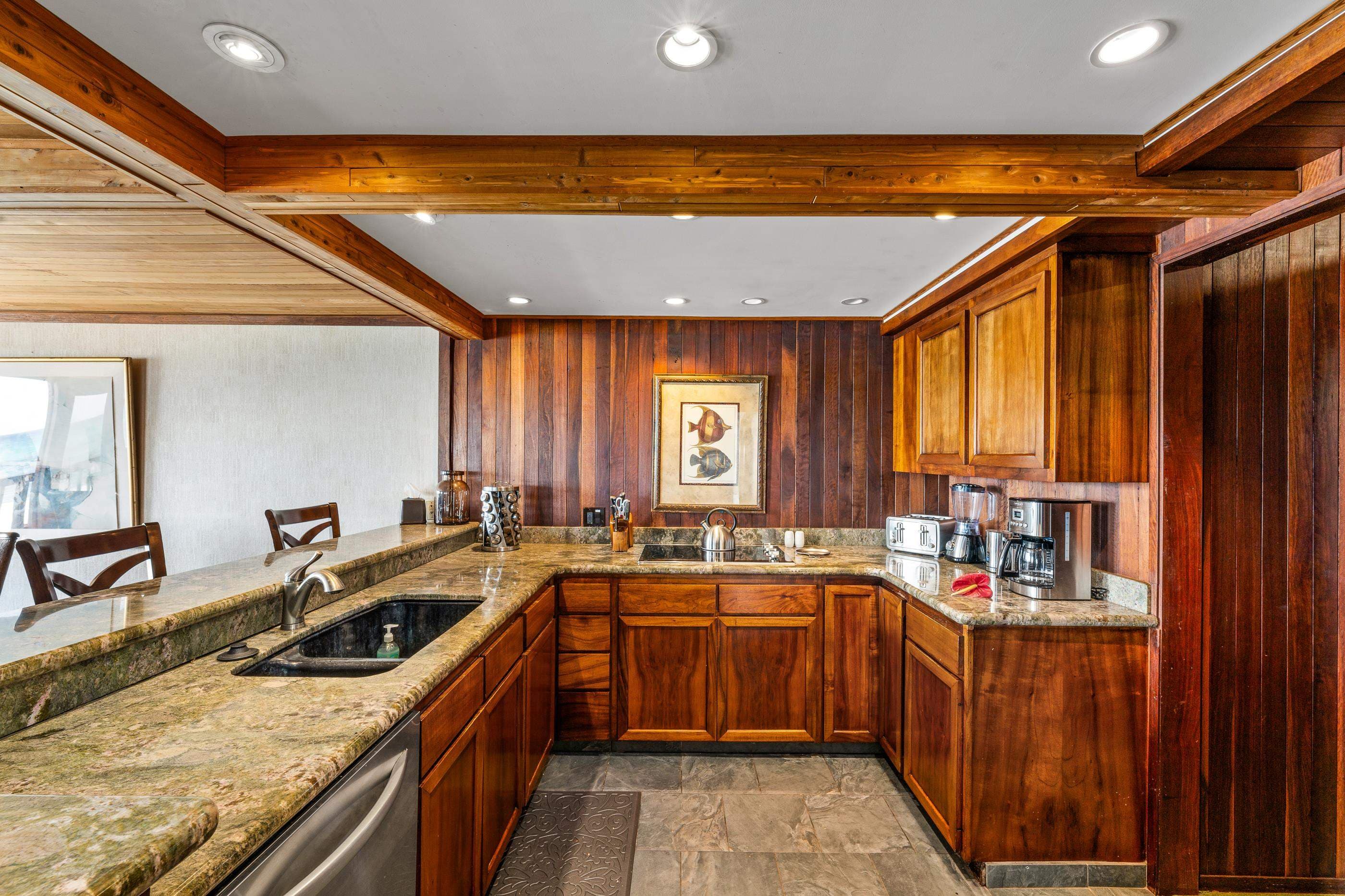 Kitchen with granite counters and koa cabinetry, morning light through the window