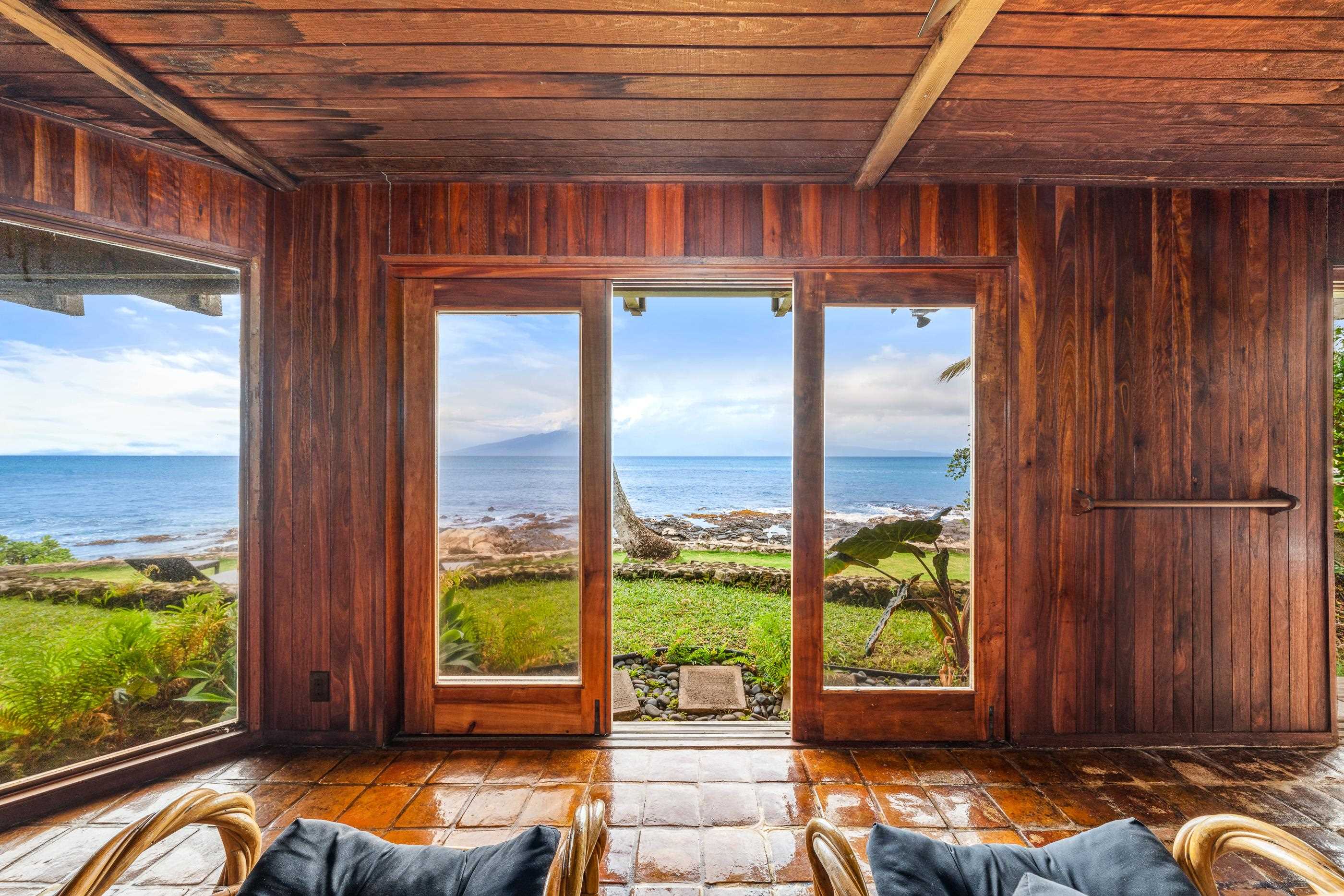 Window seat looking over the lawn to the break, cushions piled for whale watching